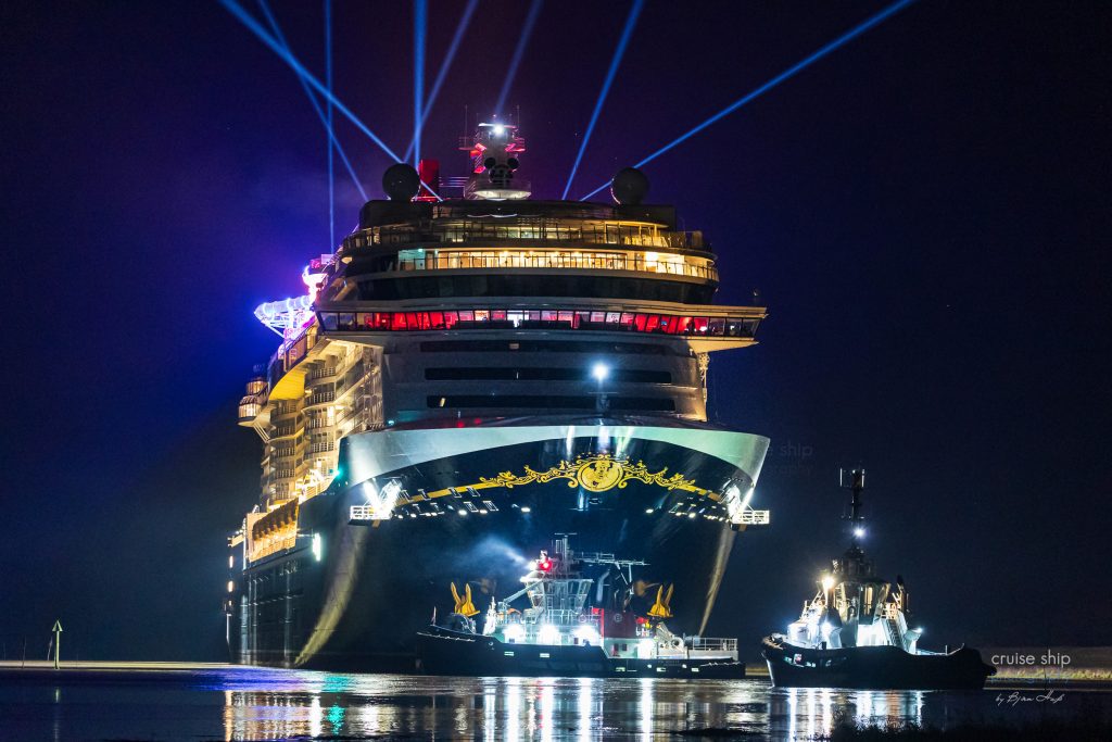 Die hell erleuchtet Disney Destiny in der Nacht mit Skytrackern auf der dunklen Ems